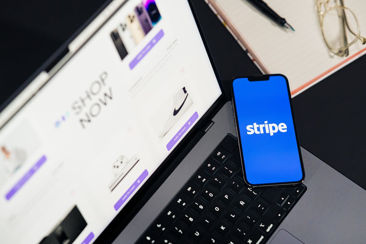 services-02 Mobile phone displaying Stripe app on a laptop with an eCommerce site open, symbolizing online shopping.