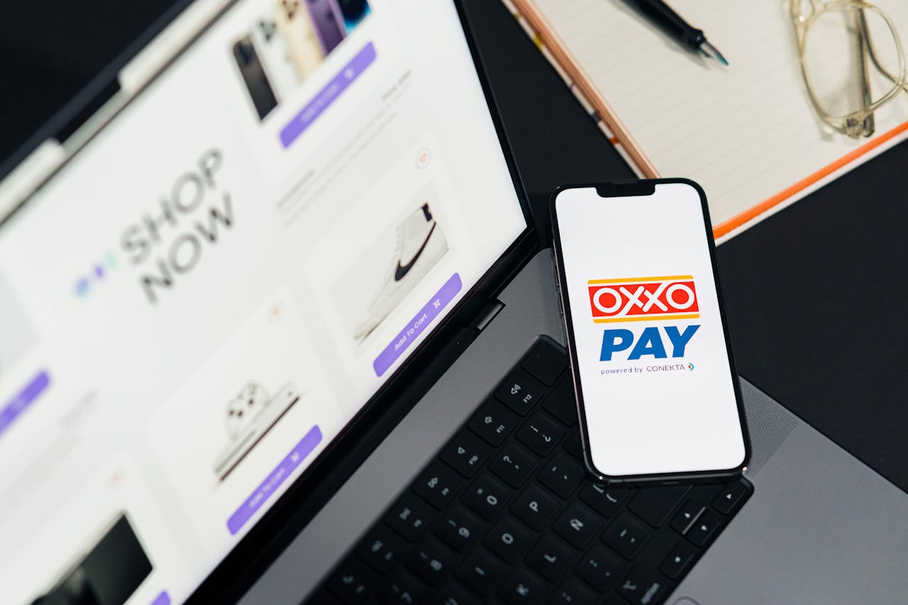 why-choose-us A mobile phone with OXXO Pay on a laptop used for online shopping.